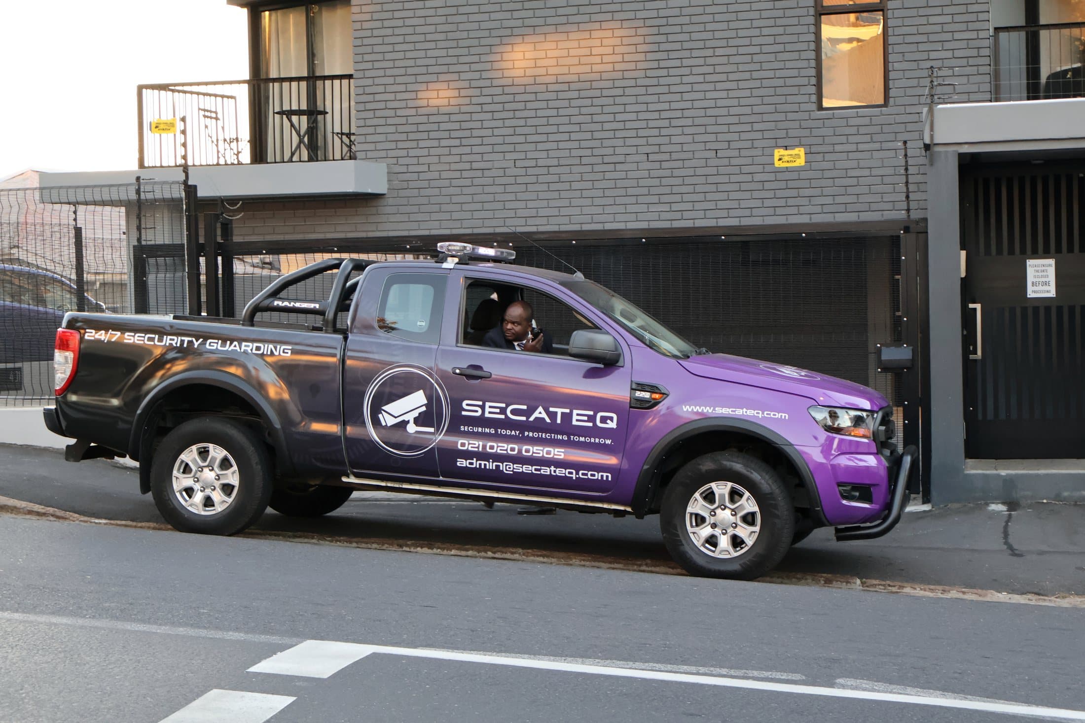 A SecaTeq Security vehicle on a Cape Town street, with the office number and admin@secateq.com on its side.