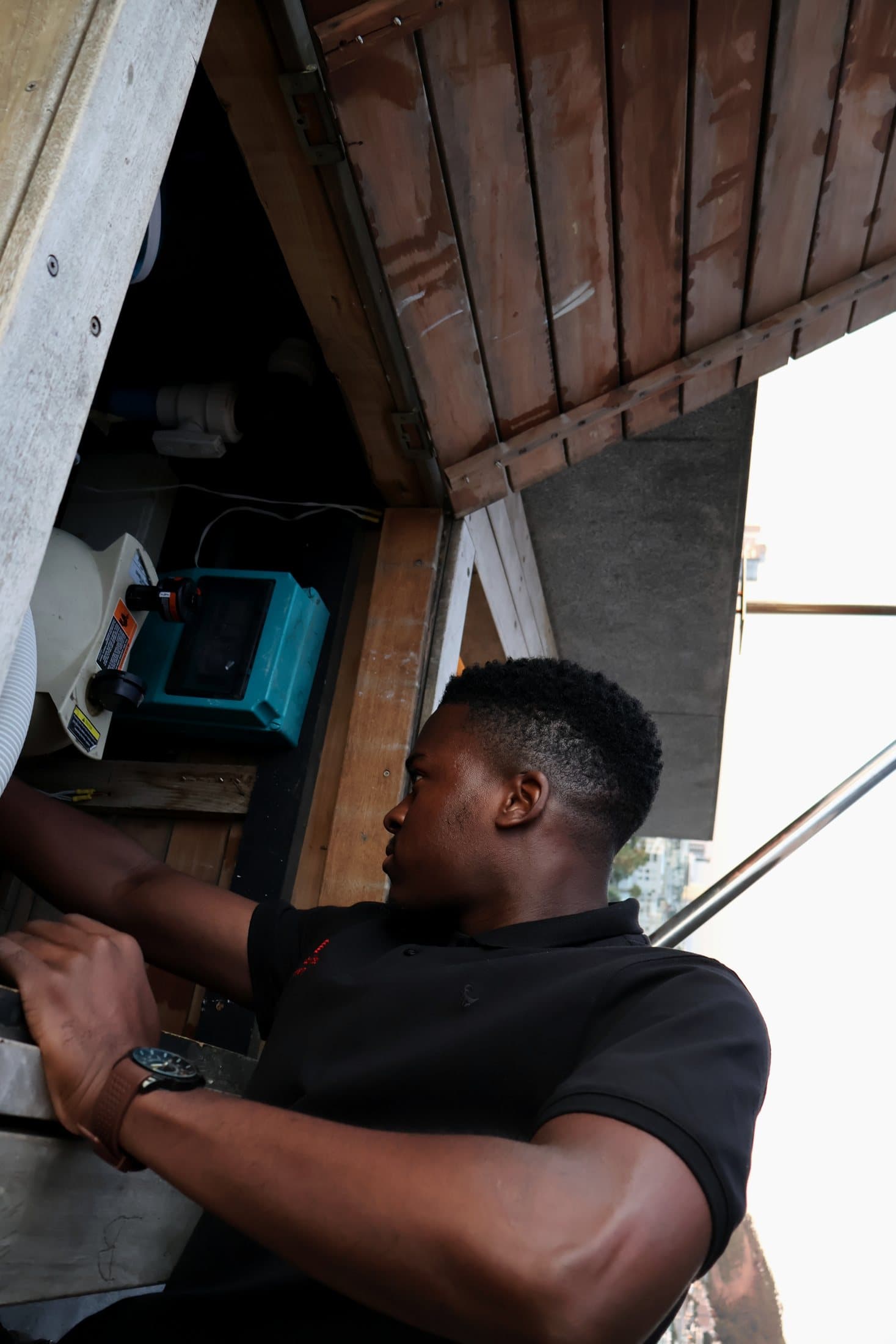 A SecaTeq FM technician working on rooftop plant through an open service hatch