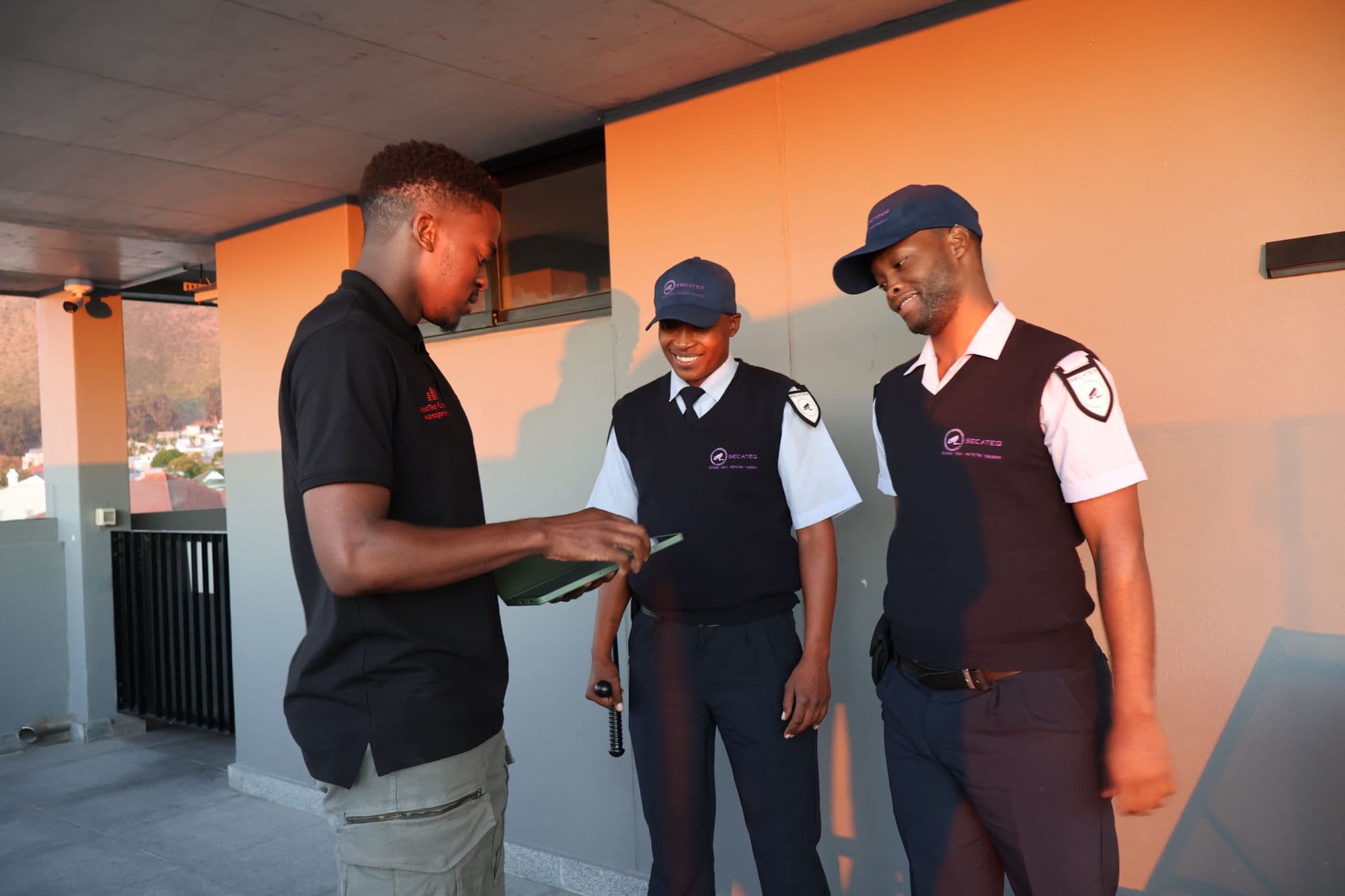 A SecaTeq FM technician going through a folder with two SecaTeq officers