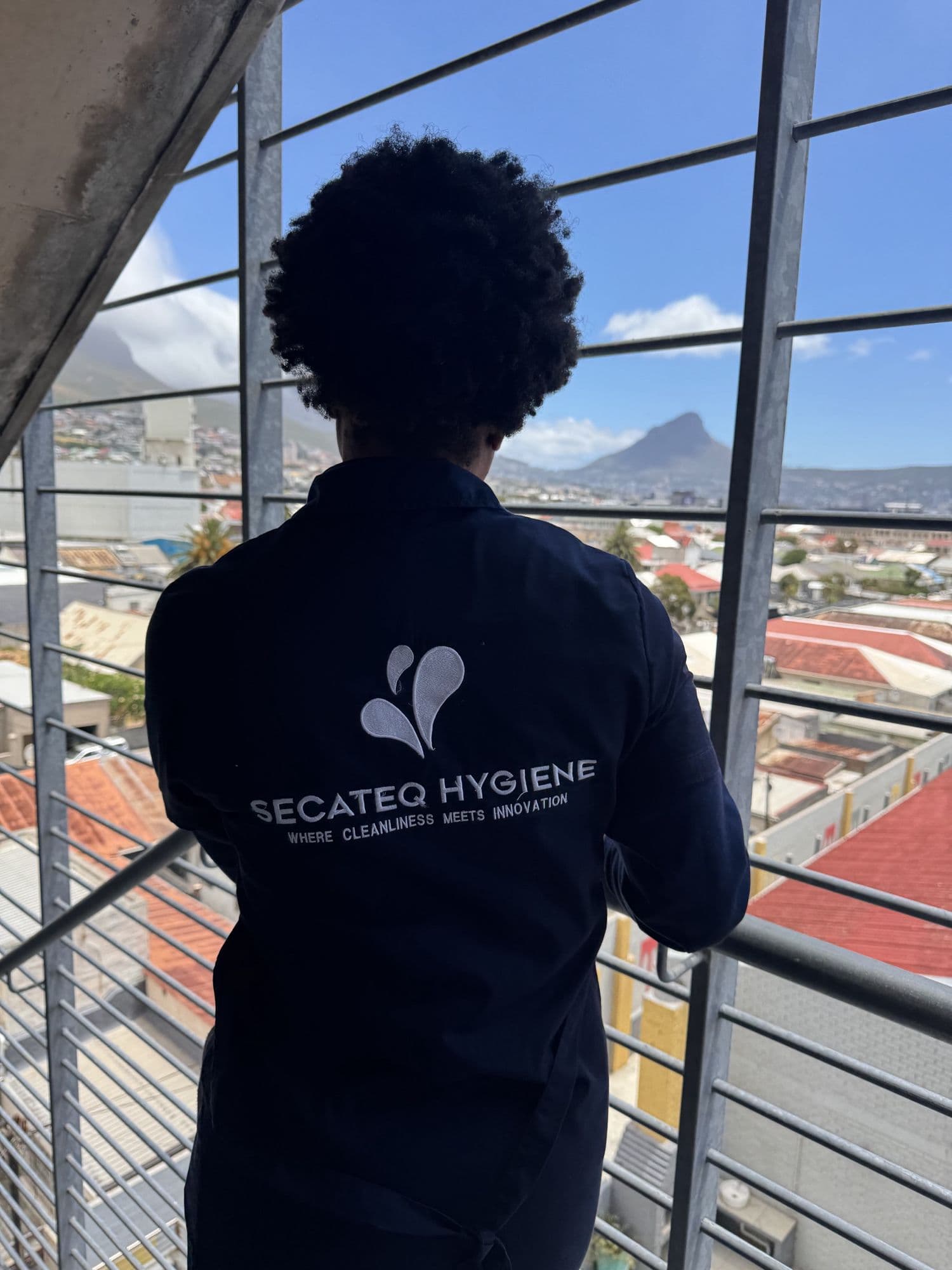 A SecaTeq Hygiene team member on a stairwell landing with Lion's Head in the distance